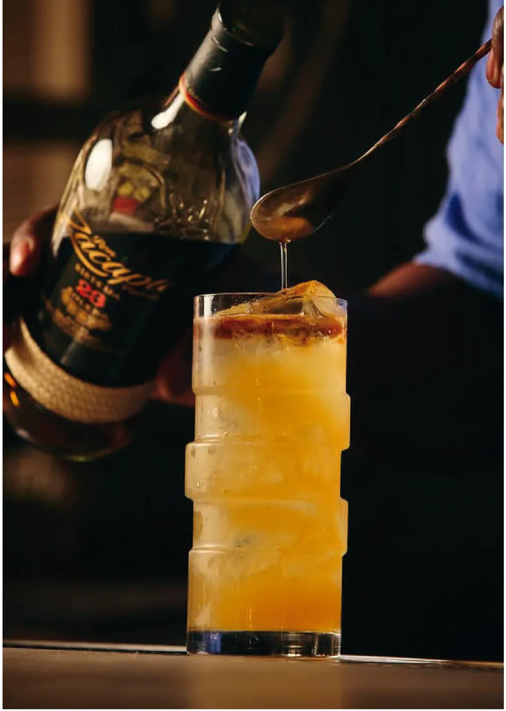 Bartender finalizando um drink servido em copo texturizado