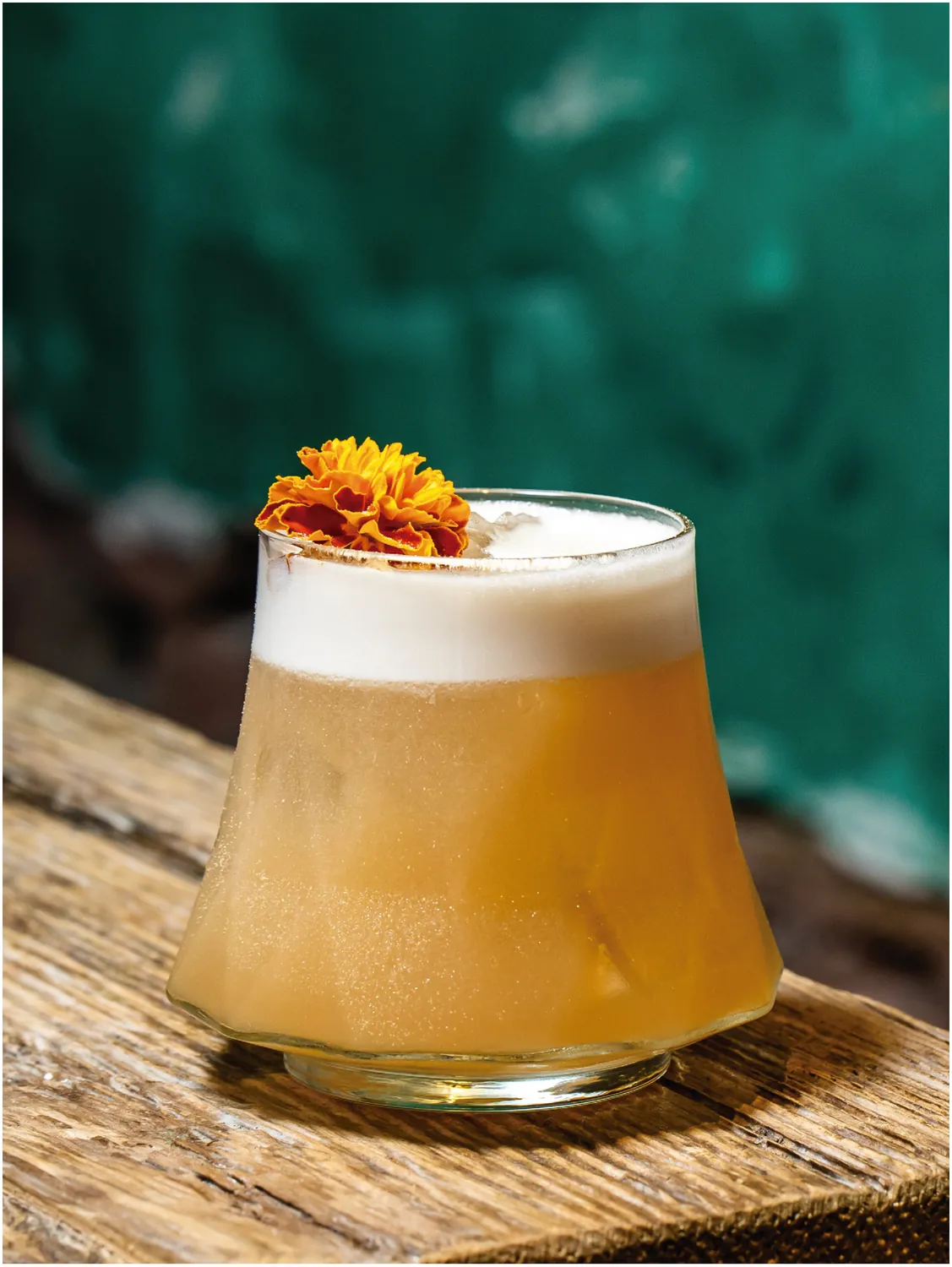 Drink sour finalizado com flor comestível em copo de bojo largo