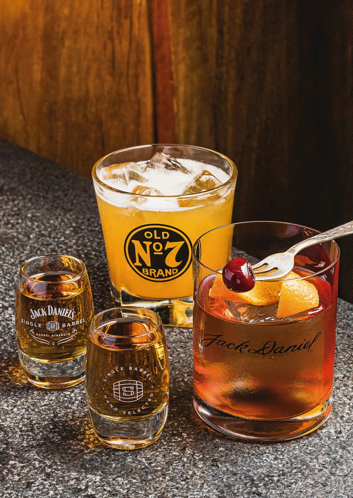Copos com gravação da marca Jack Daniel's servindo whisky e old fashioned
